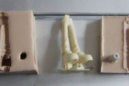Duas metades de uma fôrma de silicone com peça moldada em resina entre elas